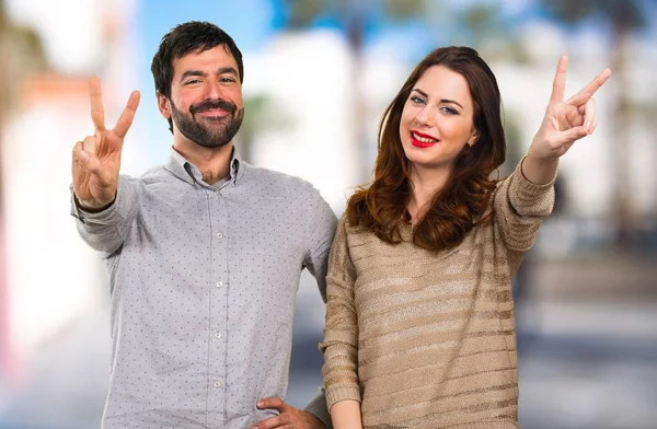 Young Couple Making Victory Gesture Unfocused Background — Stock Photo, Image