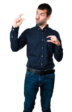 Yakışıklı adam küçük işareti izole beyaz arka plan üzerinde yapma