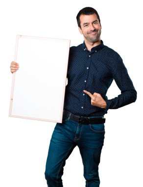 Yakışıklı adam boş bir afişini izole beyaz arka plan üzerinde tutan