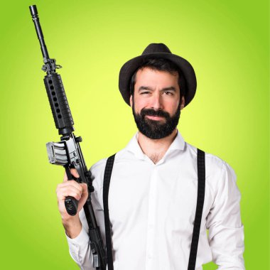 Bir tüfek renkli arka plan üzerinde tutarak sakallı hippi adam