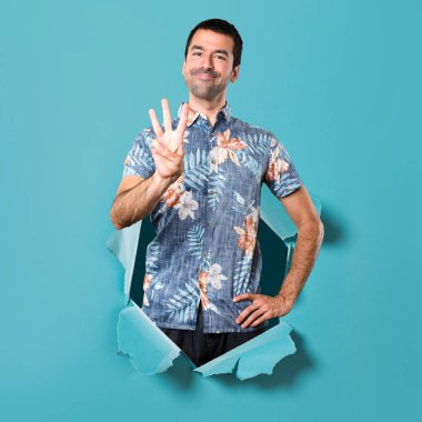 Bir mavi kağıt delikten üç sayım çiçek forması ile yakışıklı adam