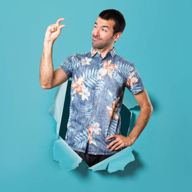 Küçük işareti mavi kağıt delik yapma çiçek forması ile yakışıklı adam