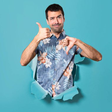 İyi-kötü işareti mavi kağıt delik yapma çiçek forması ile yakışıklı adam