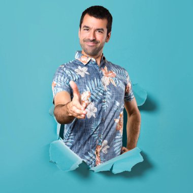 Çiçek gömlek bir mavi kağıt delik anlaşma ile yakışıklı adam