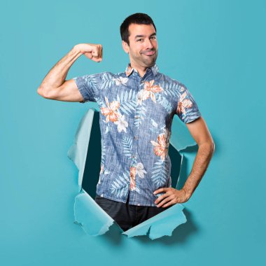 Mavi kağıt delik güçlü jest yapma çiçek forması ile yakışıklı adam