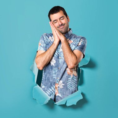 Bir mavi kağıt delikten çiçek gömlek yapma uyku hareketi ile yakışıklı adam