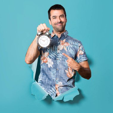 Mavi kağıt delik vintage saat tutan çiçek forması ile yakışıklı adam