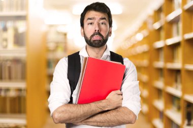 Ufuk kitaplığını üzgün öğrenci adam