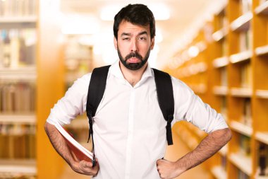 Ufuk kitaplığını üzgün öğrenci adam