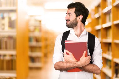 Ufuk kitaplığında lateral görünen öğrenci adam