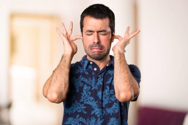 Esmer adam kulakları oda içinde kapsayan