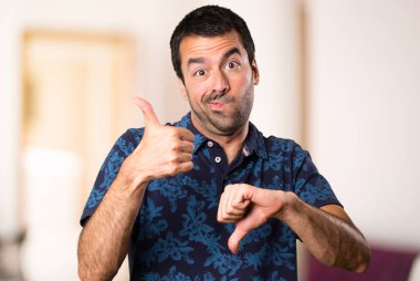 Esmer adam iyi-kötü işaret içinde oda yapma