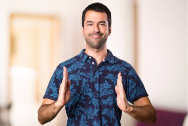 Esmer adam bir şey odanın içinde tutan