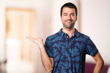 Esmer adam bir şey odanın içinde tutan