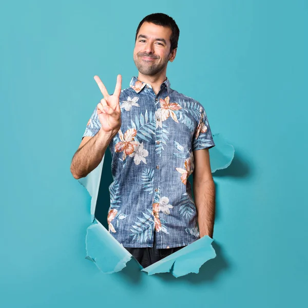 İki mavi kağıt delikten sayma çiçek forması ile yakışıklı adam