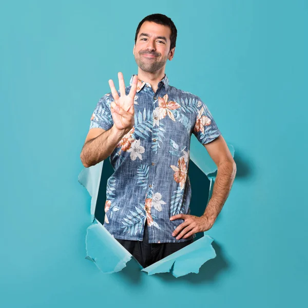 Bir mavi kağıt delikten üç sayım çiçek forması ile yakışıklı adam