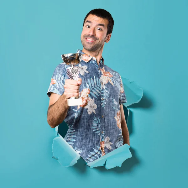Çiçek gömlek bir kupa mavi kağıt delik holding ile yakışıklı adam