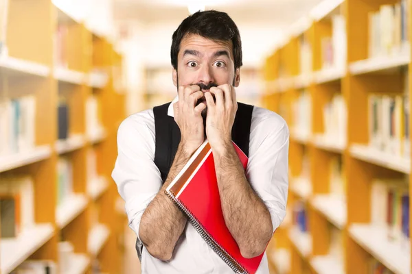 Φοβισμένος Φοιτητής Άνθρωπος Στη Defocused Βιβλιοθήκη — Φωτογραφία Αρχείου