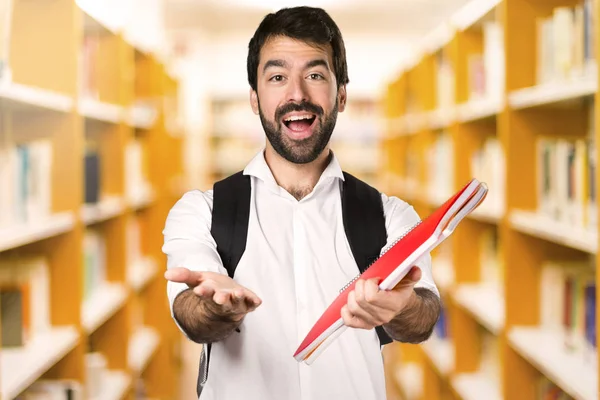 Ufuk kitaplığındaki bir şey sunan öğrenci adam