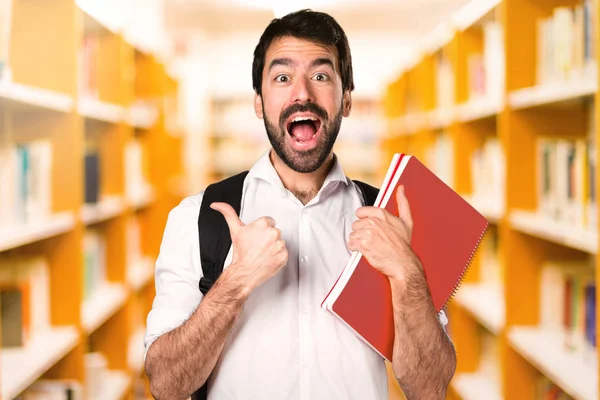 Ufuk kitaplığını başparmak ile öğrenci adam