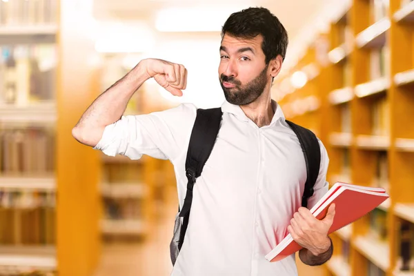 Homme Étudiant Faisant Geste Fort Sur Bibliothèque Déconcentrée — Photo