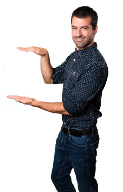 Esmer adam bir şey izole beyaz arka plan üzerinde tutan