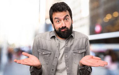 Önemsiz jest, açık hale sakallı yakışıklı adam