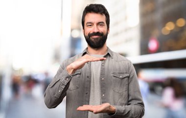 Bir şey, açık tutan sakallı yakışıklı adam