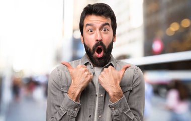 Açık, başparmak ile sakallı yakışıklı adam