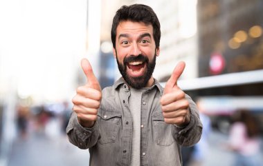 Açık, başparmak ile sakallı yakışıklı adam