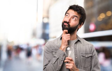 Bir ampul, açık tutarak sakallı yakışıklı adam