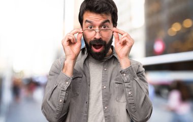 Şaşırmış yakışıklı adam sakallı ve açık, gözlüklü