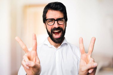 Yakışıklı adamla yapım zafer jest odaklanmamış arka plan üzerinde gözlük