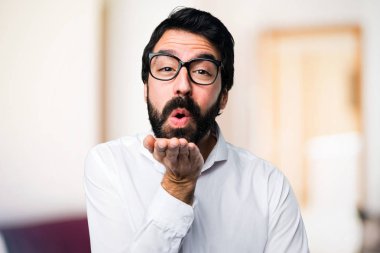 Yakışıklı adam gözlüklü odaklanmamış arka plan üzerinde bir öpücük gönderme