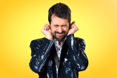 Kulakları renkli arka plan üzerinde kapsayan ceket adamla