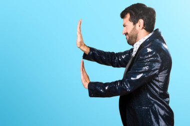 Adam bir şey renkli arka plan üzerinde iterek ceket ile