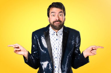 Ceket renkli arka plan üzerinde şüpheleri Laterallerin işaret eden adamla