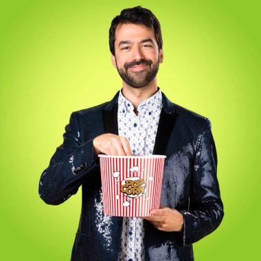 Popcorns renkli arka plan üzerinde yemek ceket adamla