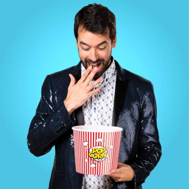 Popcorns renkli arka plan üzerinde yemek ceket adamla