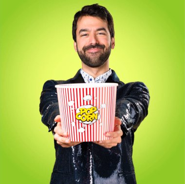 Popcorns renkli arka plan üzerinde yemek ceket adamla