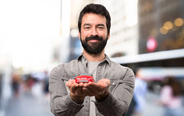Pohledný Muž Plnovousem Drží Malé Auto Venkovní — Stock fotografie