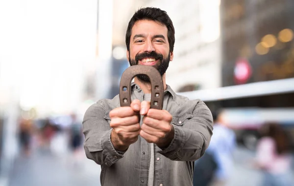 Handsome man with beard with horseshoe at outdoor