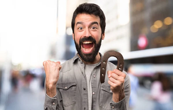Handsome man with beard with horseshoe at outdoor