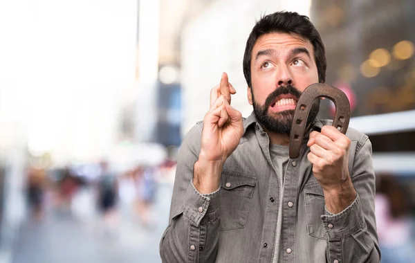 Handsome man with beard with horseshoe at outdoor