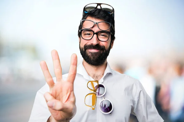 Stilig Man Med Glasögon Räknar Tre Ofokuserat Bakgrund — Stockfoto