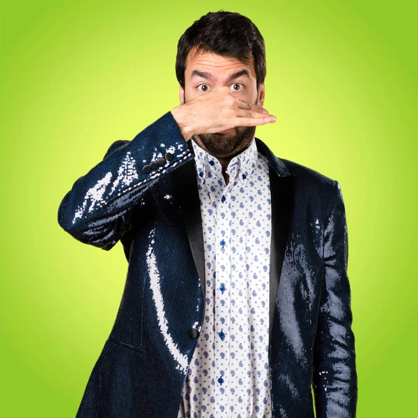 Man with jacket making smelling bad gesture on colorful background