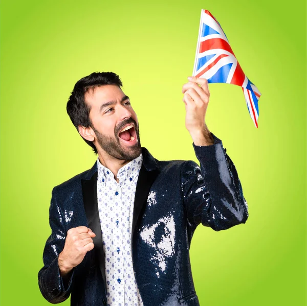 Man with jacket holding an UK flag on colorful background