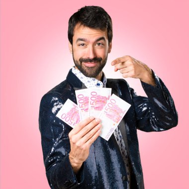 Adam renkli arka plan üzerinde bir sürü para alarak ceket ile