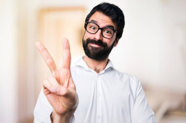 Yakışıklı adam gözlüklü iki odaklanmamış arka plan üzerinde sayma