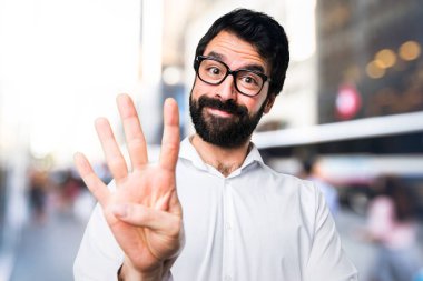 Dört odaklanmamış arka plan üzerinde sayma gözlüklü yakışıklı adam